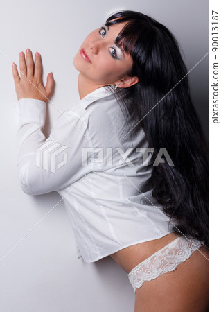 Beautiful and mature adult caucasian woman with red lips, dark hair and brown eyes wearing a black leather jacket, striped black and white top and a lace hat. 90013187