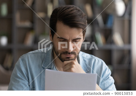 Concentrated serious male small business owner ponder on bank report Concentrated serious male small business owner ponder on bank report 90013853