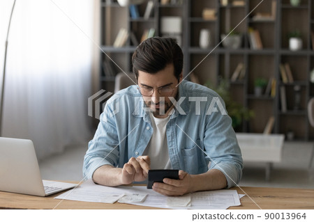 Serious young male count on calculator check financial information Serious young male count on calculator check financial information 90013964