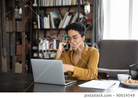 African woman talks to colleague on cellphone discuss online project 90014549