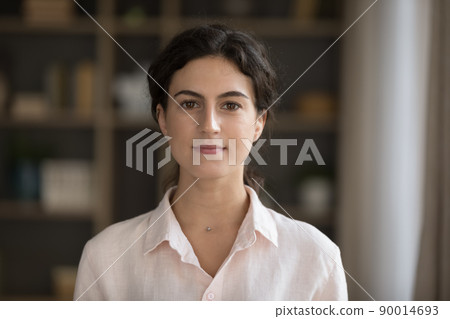 Headshot portrait serious young woman staring at camera pose indoor 90014693