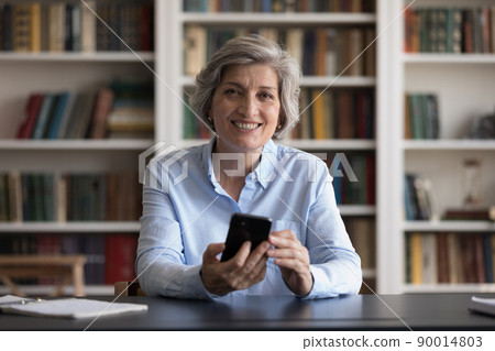 Happy mature business professional woman holding mobile phone 90014803