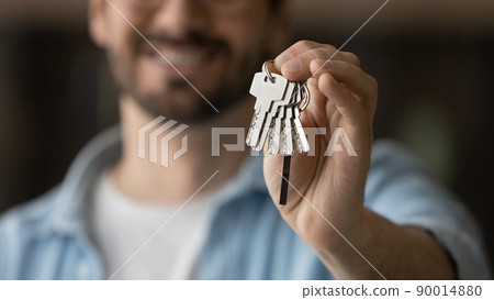 Young man realty buyer or seller holding keys in hand Young man realty buyer or seller holding keys in hand 90014880