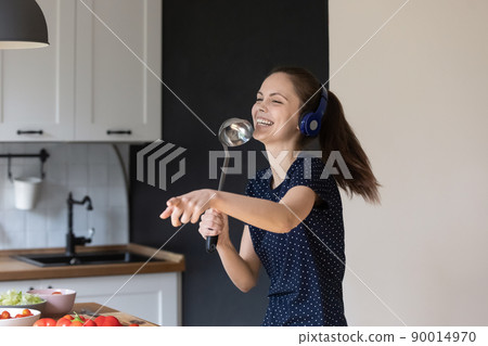 Excited joyful young girl enjoying domestic entertainment 90014970