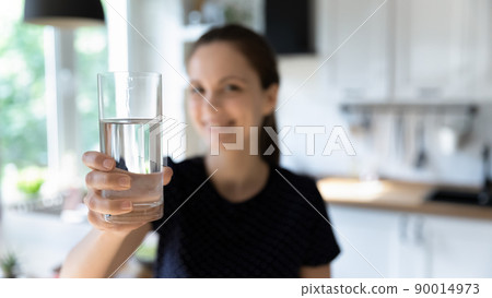 Happy young woman drinking clean mineral water in home kitchen 90014973