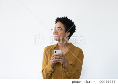 Happy African woman holds cellphone pose alone on white background 90015111