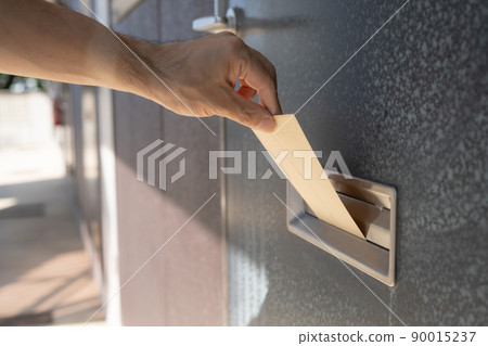 Hands to put envelopes in the mailbox at the entrance Hands to put envelopes in the mailbox at the entrance 90015237