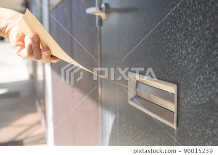Hands to put envelopes in the mailbox at the entrance 90015239