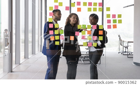 Leader of project explain to teammates information on sticky notes Leader of project explain to teammates information on sticky notes 90015362