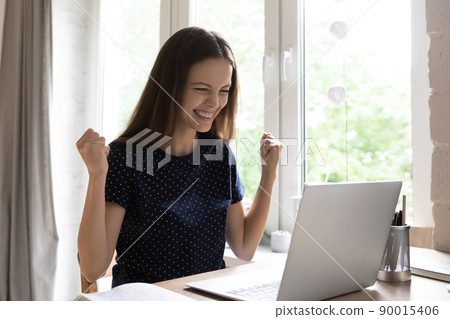 Happy girl making winner yes hands at laptop 90015406
