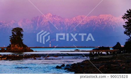 A spectacular view of the Tateyama mountain range dyed in the setting sun over Toyama Bay from the Amaharashi coast in Takaoka City, Toyama Prefecture 90015828