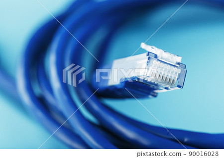 A coil of an Internet network cable for data transmission on a blue background 90016028