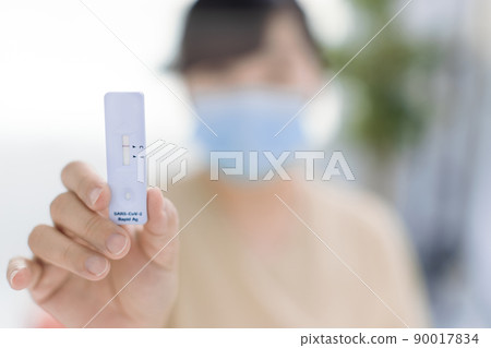 Woman showing antigen self test card  Covid-19 90017834