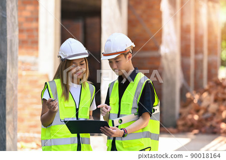 Team of construction engineers discussing the design of construction together Team of construction engineers discussing the design of construction together 90018164