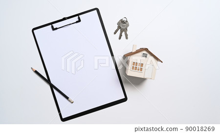 Above view house model, keys and clipboard on white background. Real estate investment and insurance concept 90018269