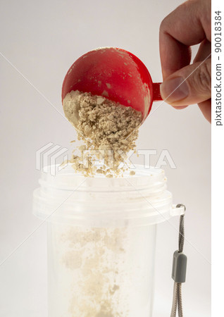 Woman pours collagen powder or protein in a glass of water on a beige background. A healthy and anti aging supplement. Copy space Woman pours collagen powder or protein in a glass of water on a beige background. A healthy and anti aging supplement. Copy space 90018384