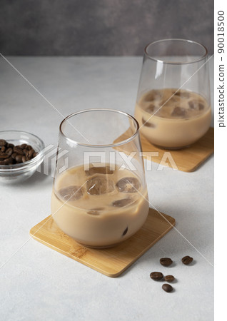Irish cream liqueur in two glasses with ice cubes and coffee beans 90018500