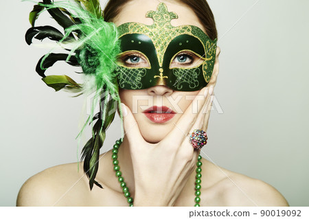 The beautiful young woman in a green mysterious venetian mask 90019092