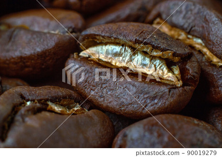 Roasted coffee beans scattered in random order on a dark background 90019279