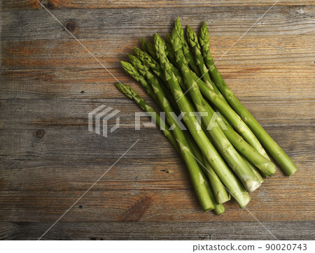 a bundle of asparagus on a wooden background with room for text 90020743