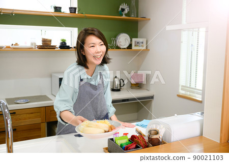Housewife making breakfast in the kitchen 90021103