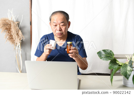 老人在電腦前拿著藥 90022142