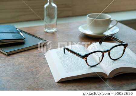 Morning reading with a cup of coffee gracefully at a desk by the window in a retro atmosphere Morning reading with a cup of coffee gracefully at a desk by the window in a retro atmosphere 90022630