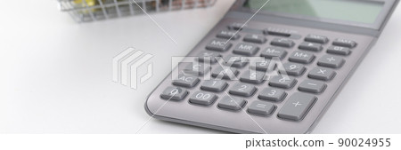 Calculator and basket with pills and capsules, close-up 90024955