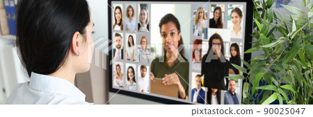 Woman looking at the display screen at the photo of people 90025047