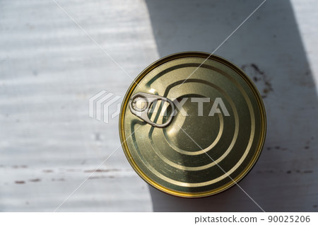 Canned food in a metal cylindrical container. Closed Tin can with ready-to-eat food. Selective focus. 90025206