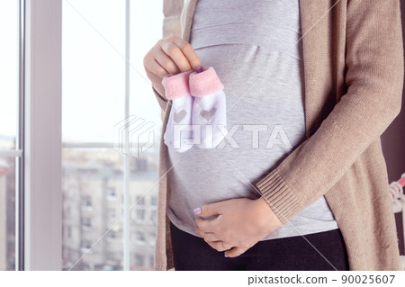 Pregnant woman by the window. Close up. Pregnant woman by the window. Close up. 90025607