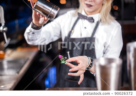 Girl bartender creates a cocktail on the public house Girl bartender creates a cocktail on the public house 90026372