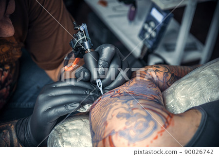 Professional tattooist makes tattoo pictures in studio Professional tattooist makes tattoo pictures in studio 90026742