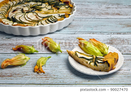 A slice of zucchini courgette and cheese pie on a white plate 90027470