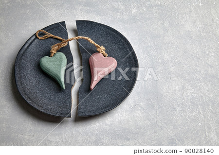 Wooden hearts tied with twine lie on a broken plate Wooden hearts tied with twine lie on a broken plate 90028140