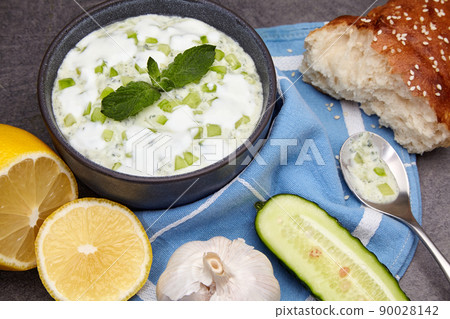 Yogurt sauce with cucumber, mint, garlic and lemon surrounded by ingredients Yogurt sauce with cucumber, mint, garlic and lemon surrounded by ingredients 90028142