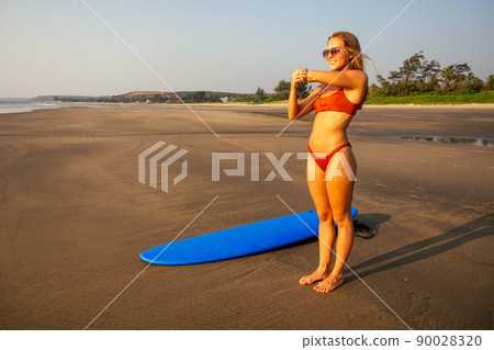 beautiful surfer girl on the beach at sunset.female model smiles and runs into the sea with lots of splashes tropical island paradise .sports woman with surfboard summer vacation beautiful surfer girl on the beach at sunset.female model smiles and runs into the sea with lots of splashes tropical island paradise .sports woman with surfboard summer vacation 90028320