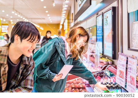 Men and women buying sushi at supermarkets 90030052