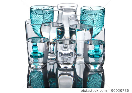 Pure drinking water is poured into different glass goblets isolated on white background 90030786
