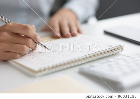 Closeup of person marking with pen and looking at date on calendar Closeup of person marking with pen and looking at date on calendar 90031185