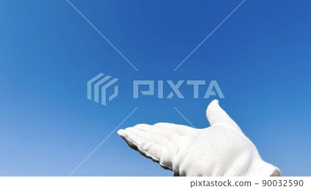 Hand with white gloves in the blue sky_left space 90032590