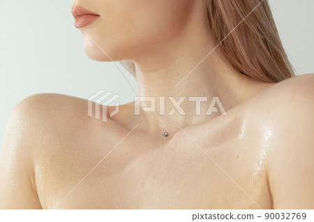 Cropped image of beautiful female body, tender slim collarbone isolated over grey studio backgrorund 90032769