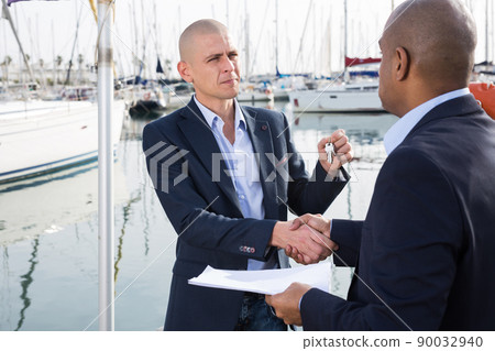 men with documents and keys near the yachts in the port men with documents and keys near the yachts in the port 90032940