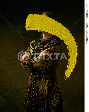 Creative artwork. Portrait of girl in image of medieval princess or countess with yellow stroke of watercolor paint over dark background. Contemporary art, eras comparison concept Creative artwork. Portrait of girl in image of medieval princess or countess with yellow stroke of watercolor paint over dark background. Contemporary art, eras comparison concept 90032945