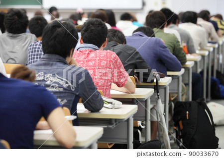 大學教室裡坐在課桌前學習的男學生的後視圖 大學教室裡坐在課桌前學習的男學生的後視圖 90033670