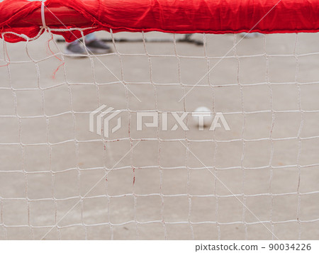 Floorball goal. Children playing outdoor in spring. Floor hockey players goalkeeper running with ball and sticks Floorball goal. Children playing outdoor in spring. Floor hockey players goalkeeper running with ball and sticks 90034226