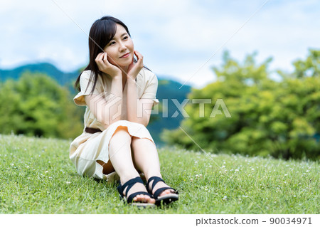 Young woman relaxing on the lawn Young woman relaxing on the lawn 90034971