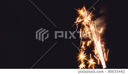 Burning flare or flame with bright sparks and smoke from a burnt candle on background with copy space. festive event concept. Burning flare or flame with bright sparks and smoke from a burnt candle on background with copy space. festive event concept. 90035442