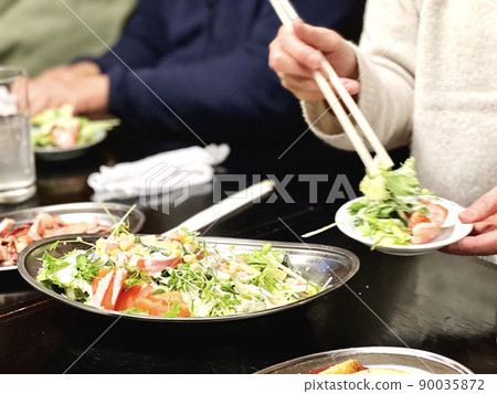 A woman sharing a salad at a home party A woman sharing a salad at a home party 90035872