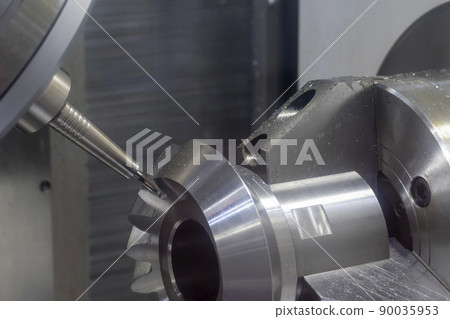 The 5-axis CNC milling machine cutting the metal gear part. The 5-axis CNC milling machine cutting the metal gear part. 90035953